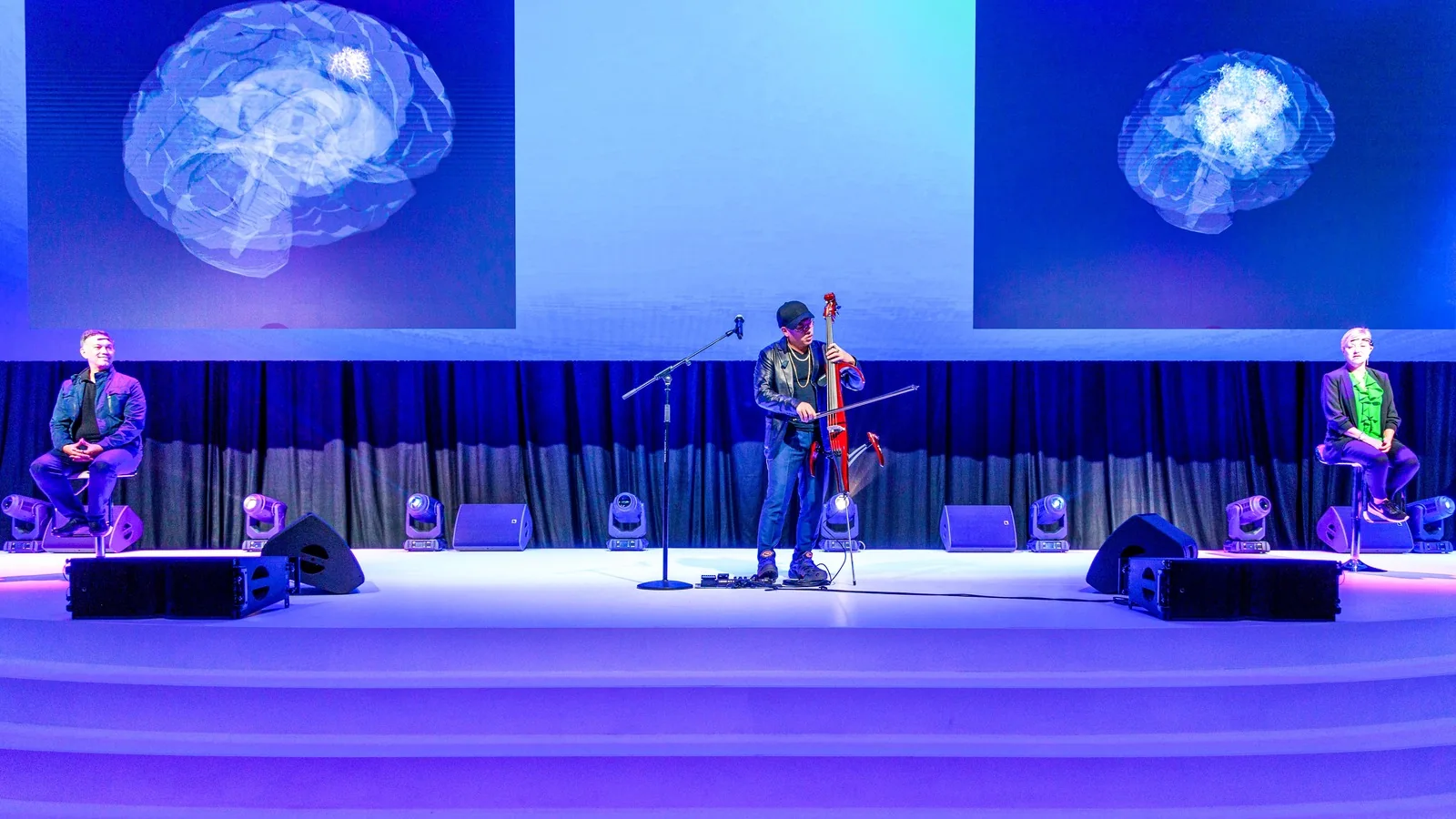 Wide view of the NeuroSymphony keynote at Marina Bay Sands, brain scan visuals on giant screens above a full audience