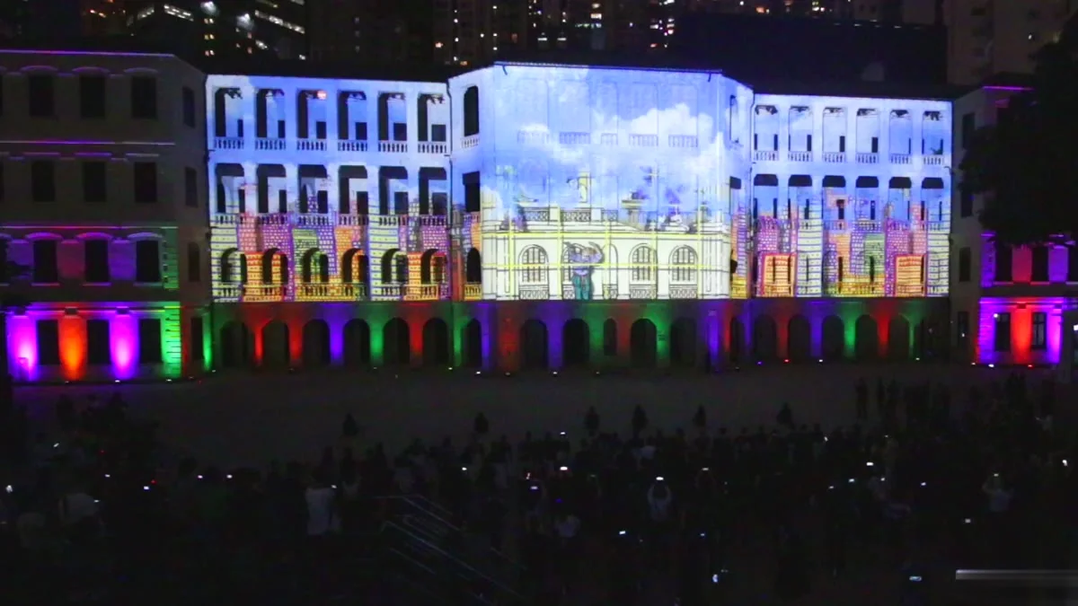The Tai Kwun compound in Hong Kong lit end to end by projection mapping with a packed courtyard below